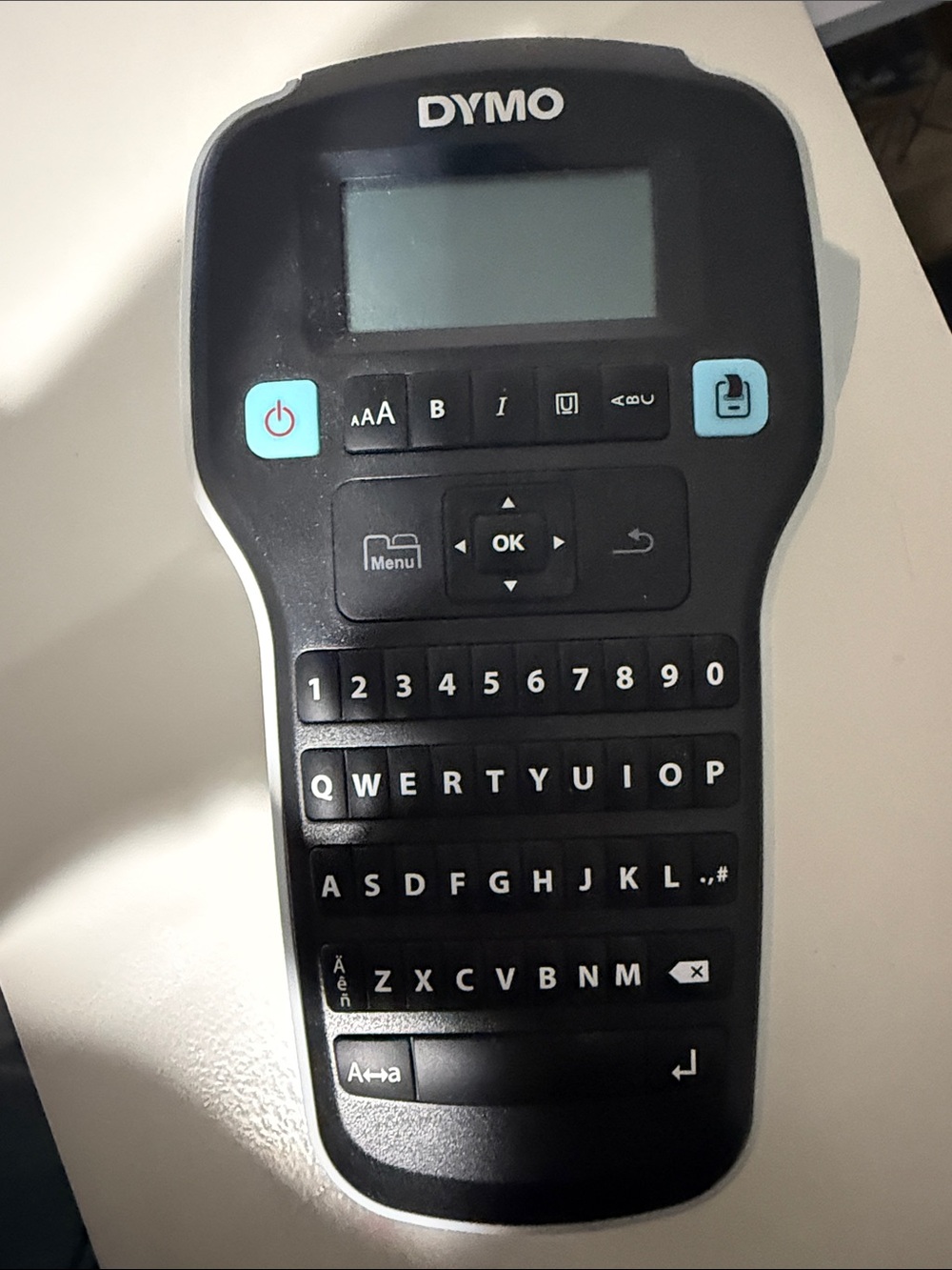 Dymo handheld label maker in black with light blue buttons
